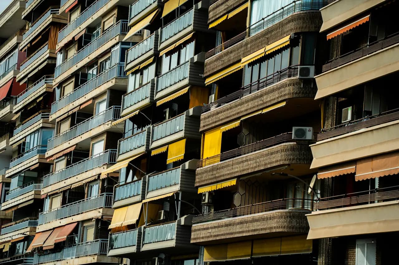 Técnico em plataforma suspensa inspecionando fachada de edifício